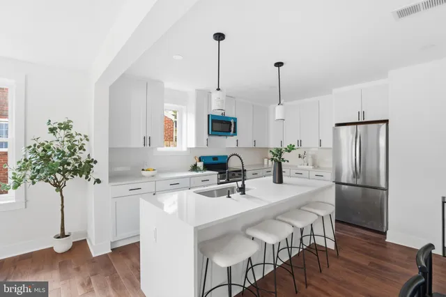 a kitchen with kitchen island white cabinets and stainless steel appliances