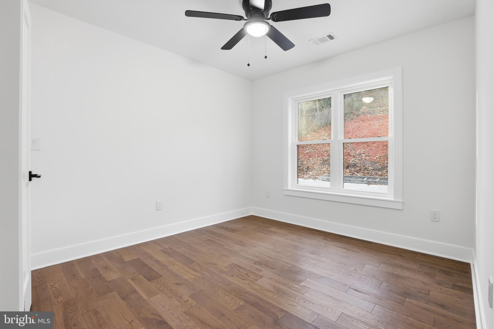 413 Williamsburg Drive Silver Spring, MD 20901 - Photo 26 of 33 an empty room with wooden floor ceiling fan and windows