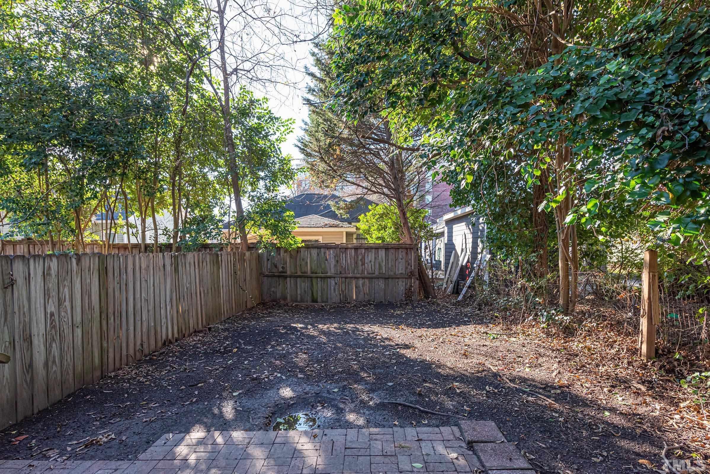 619 Hinsdale Street Raleigh, NC 27605 - Photo 14 of 34 a view of a backyard with large trees and wooden fence