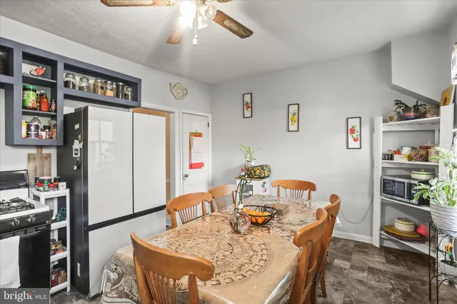 a living room with stainless steel appliances furniture a rug and a kitchen view