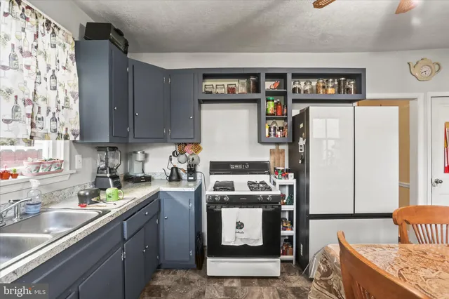a kitchen with stainless steel appliances granite countertop a refrigerator sink and stove