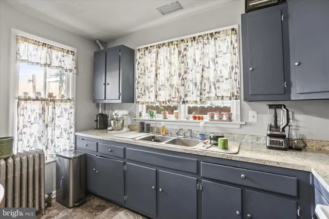 a kitchen with a sink a window and cabinets