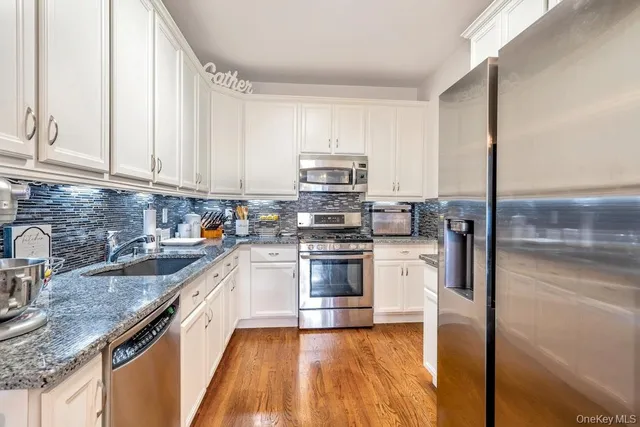 a kitchen with granite countertop a sink stove and refrigerator