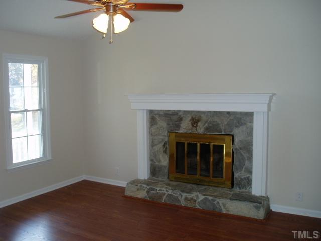 7309 Shawan Road Wendell, NC 27591 - Photo 3 of 12 Living room has a wood burning fireplace with custom stonework and mantle, and new laminate flooring