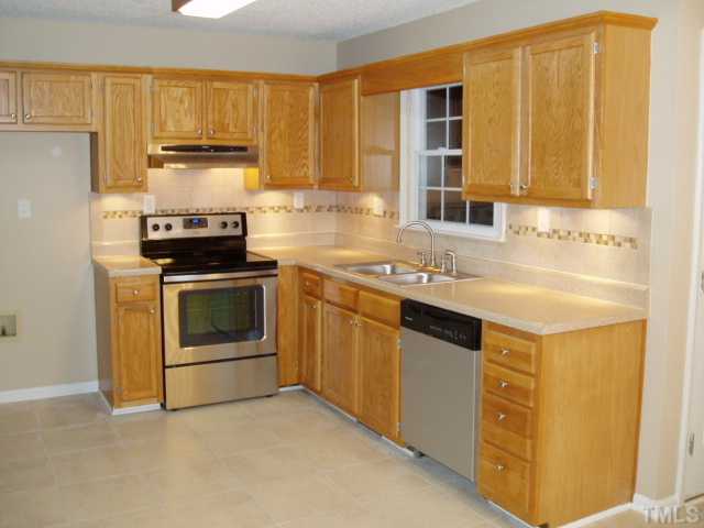 7309 Shawan Road Wendell, NC 27591 - Photo 5 of 12 Kitchen has new stainless steel appliances (smooth top stove), new stainless sink and faucet. Custom tile backsplash with under cabinet lighting. New 16" ceramic tile floor.