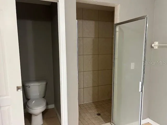 a bathroom with a toilet and a shower