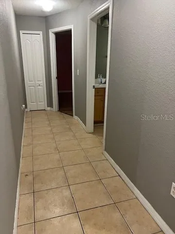 a view of an empty room with closet and bathroom