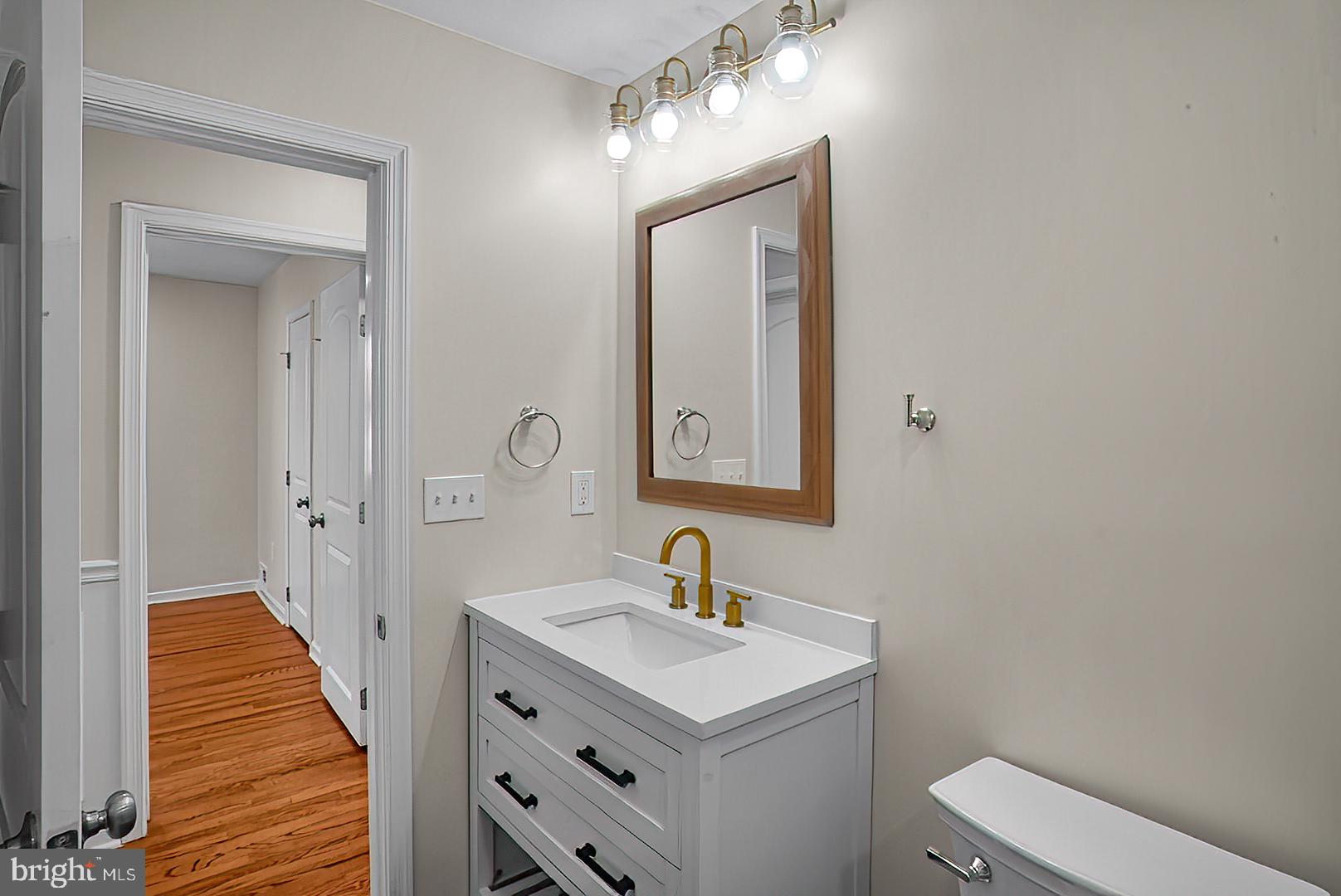 3316 Fairview Road Baltimore, MD 21207 - Photo 11 of 41 a bathroom with a toilet a sink a mirror and vanity