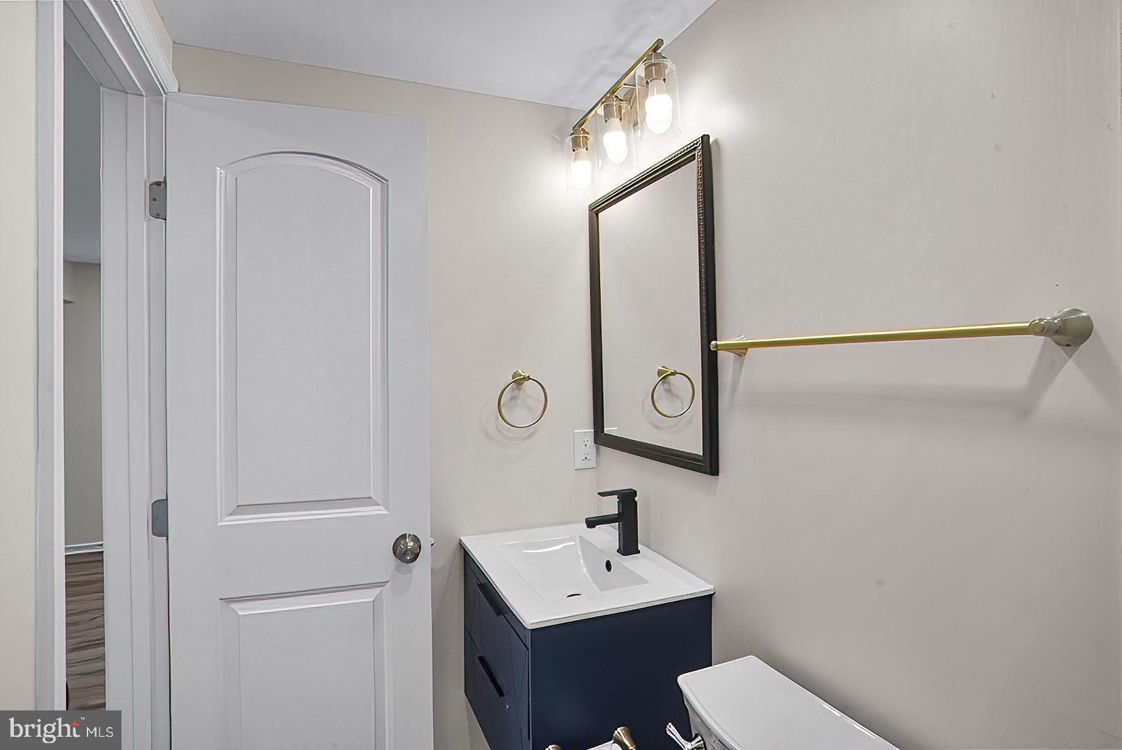 3316 Fairview Road Baltimore, MD 21207 - Photo 10 of 41 a bathroom with a toilet a sink and mirror