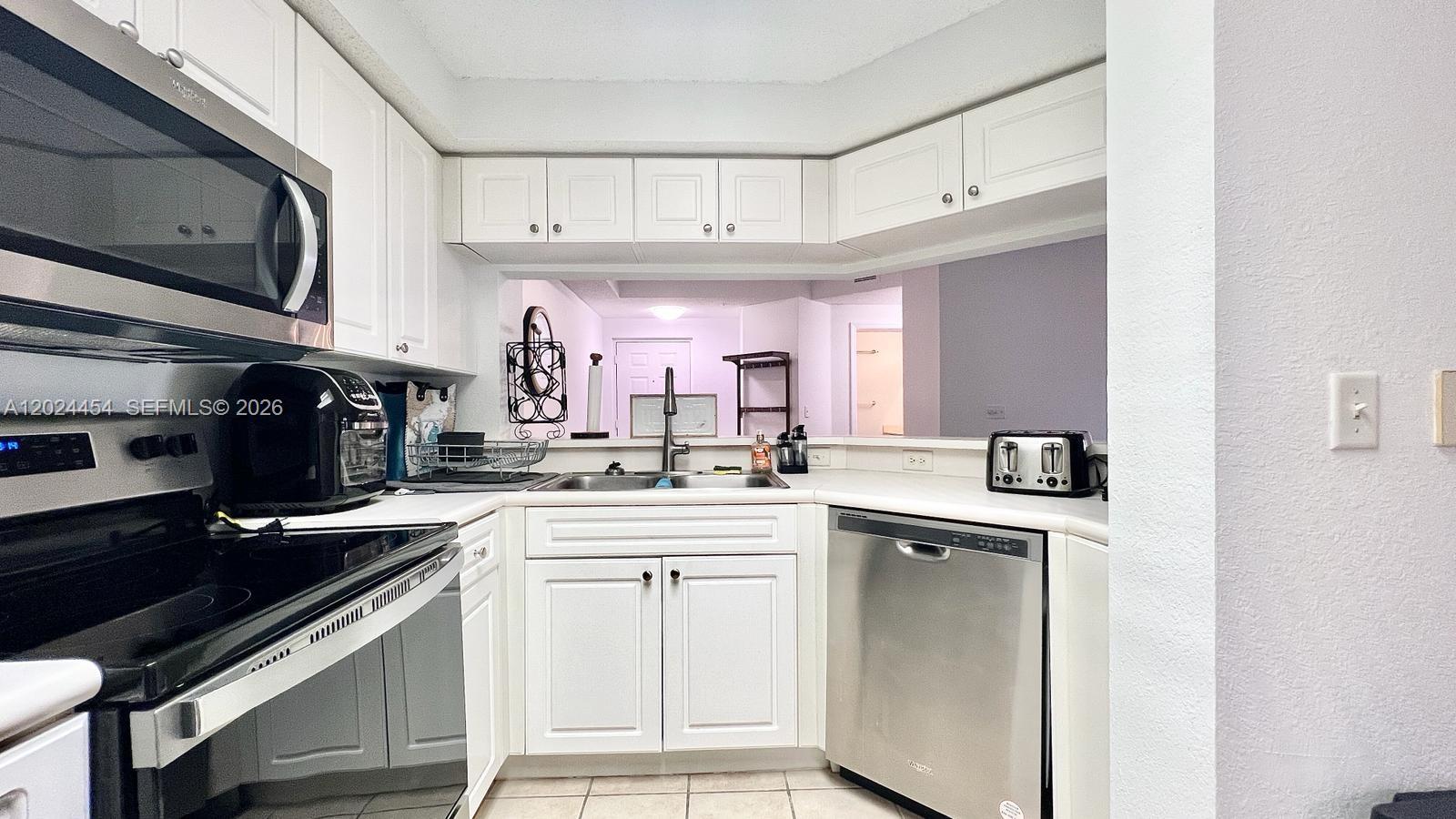 2727 Anzio Court, Unit 106 Palm Beach Gardens, FL 33410 - Photo 10 of 43 a kitchen with a sink cabinets and stainless steel appliances