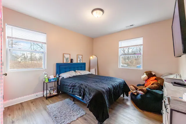 a bedroom with a bed and wooden floor