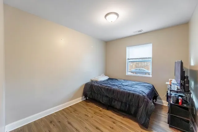 a bedroom with a bed and a flat tv screen on the dresser