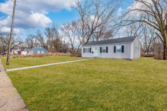 a view of a house with a big yard and palm trees