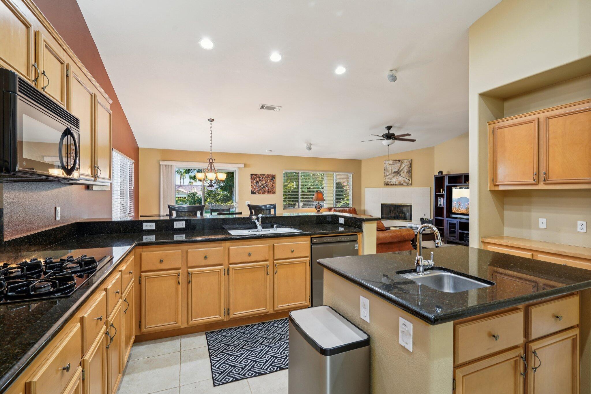 49382 Wayne Street Indio, CA 92201 - Photo 15 of 69 a kitchen with a stove a sink a dining table and chairs