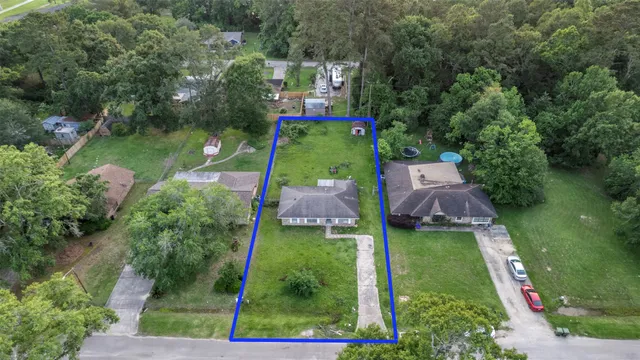 an aerial view of a house with swimming pool outdoor seating barbeque oven and green space