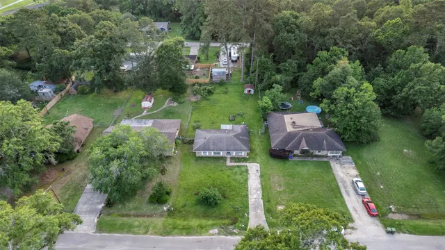 an aerial view of a house with swimming pool a patio and yard