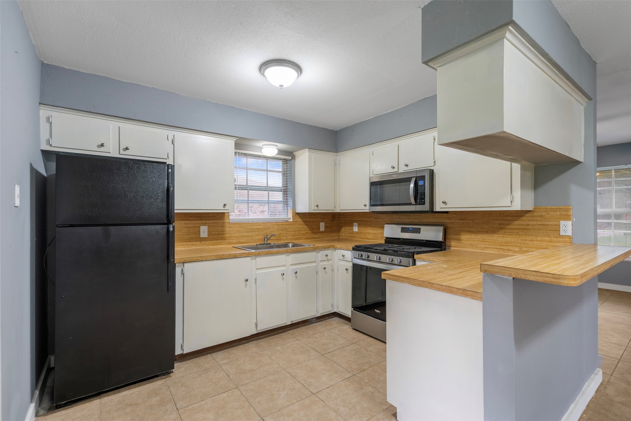 1204 Crescent Boulevard Cleveland, TX 77327 - Photo 5 of 24 a kitchen with a refrigerator sink and microwave