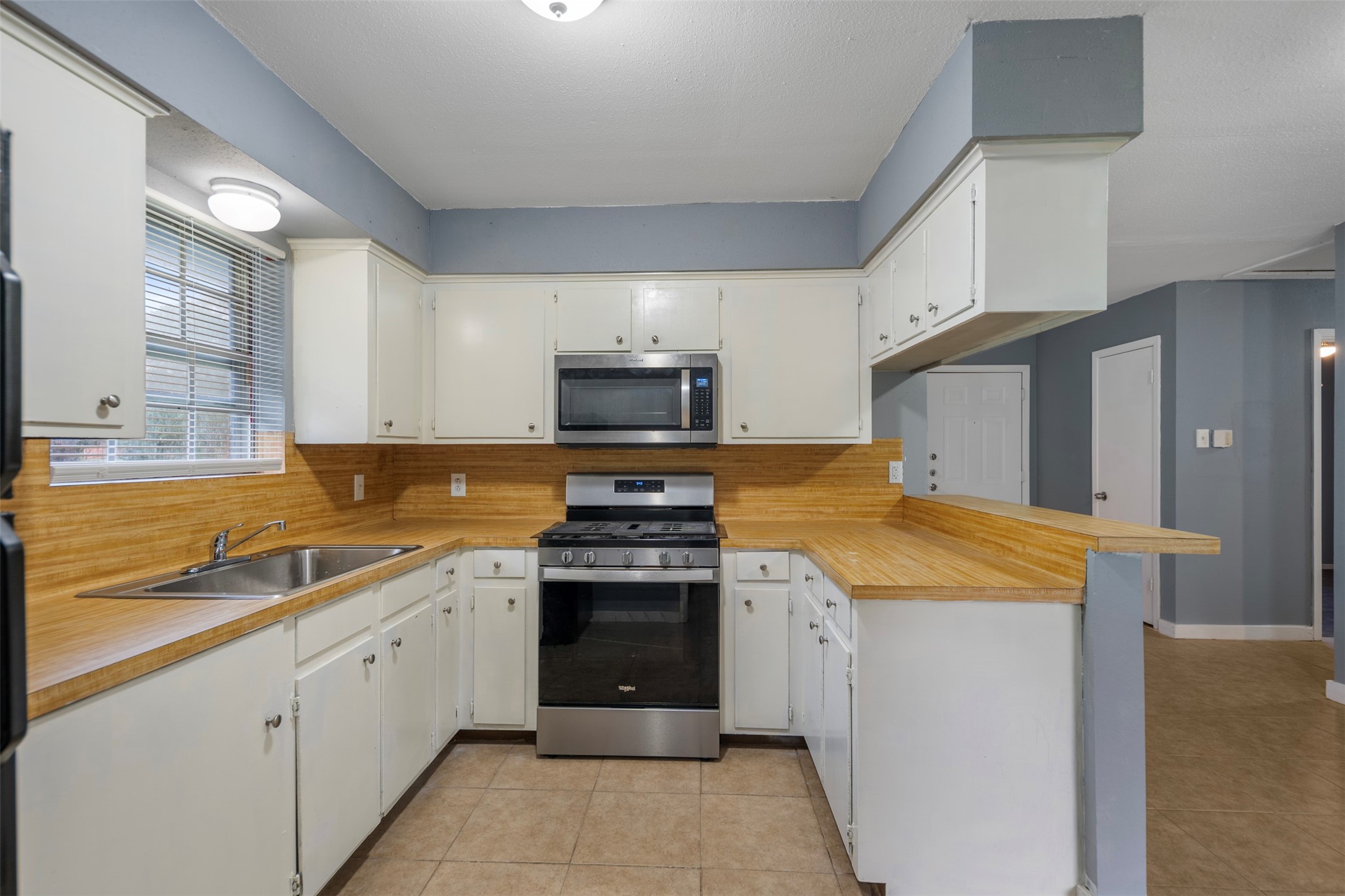 1204 Crescent Boulevard Cleveland, TX 77327 - Photo 6 of 24 a kitchen that has a sink and a stove
