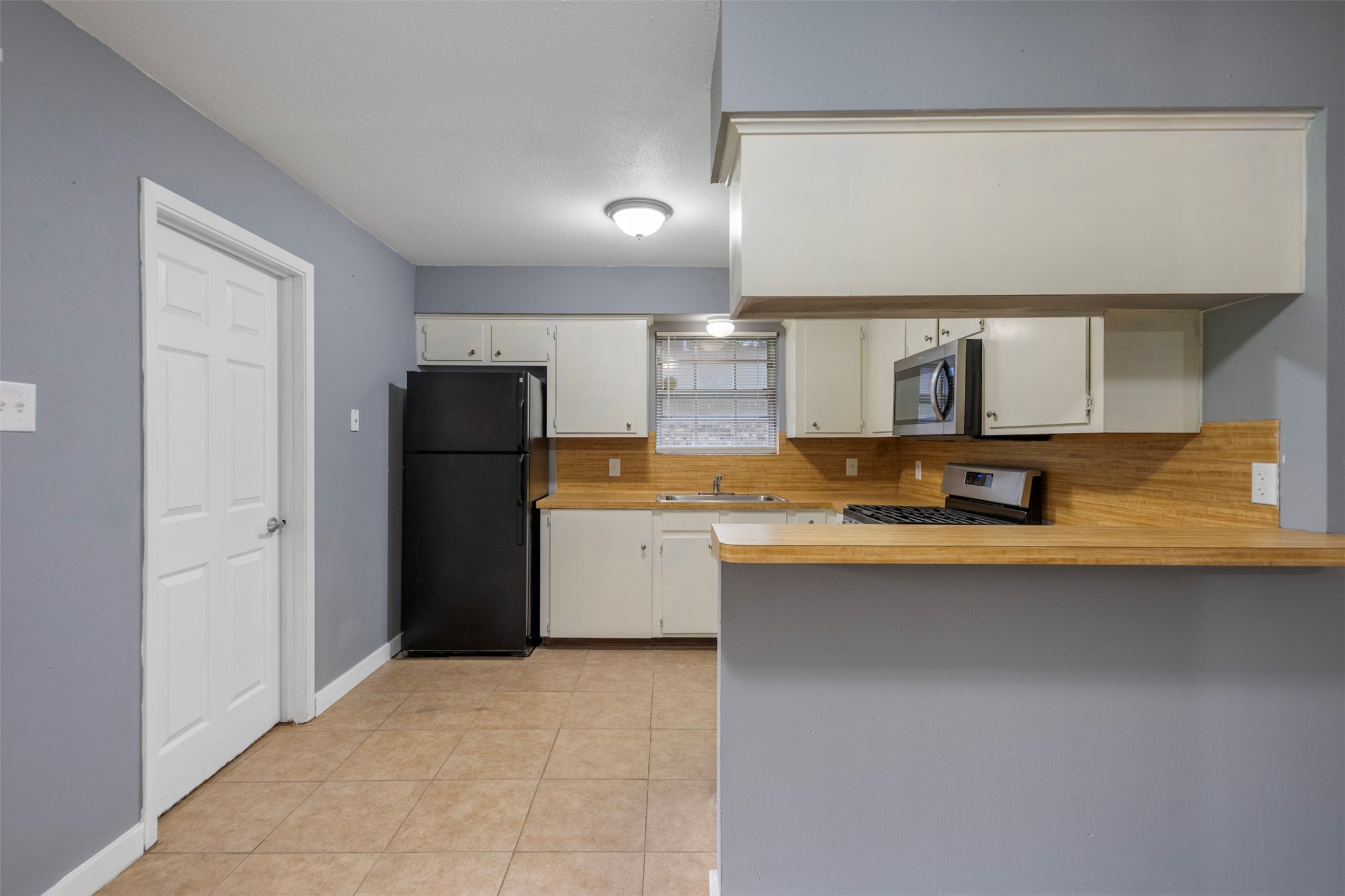 1204 Crescent Boulevard Cleveland, TX 77327 - Photo 7 of 24 a kitchen with granite countertop a refrigerator a sink and a stove