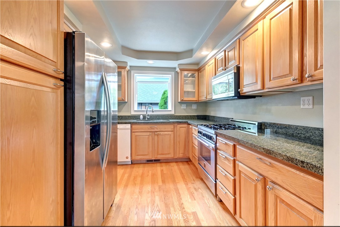 425 South Cabot Road Everett, WA 98203 - Photo 8 of 24 a kitchen with stainless steel appliances granite countertop a refrigerator a sink dishwasher a stove and white countertops with wooden floor