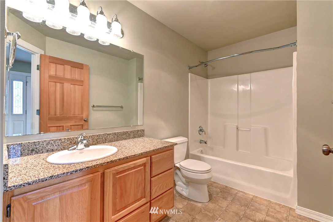 425 South Cabot Road Everett, WA 98203 - Photo 10 of 24 a bathroom with a granite countertop sink a toilet a mirror and shower