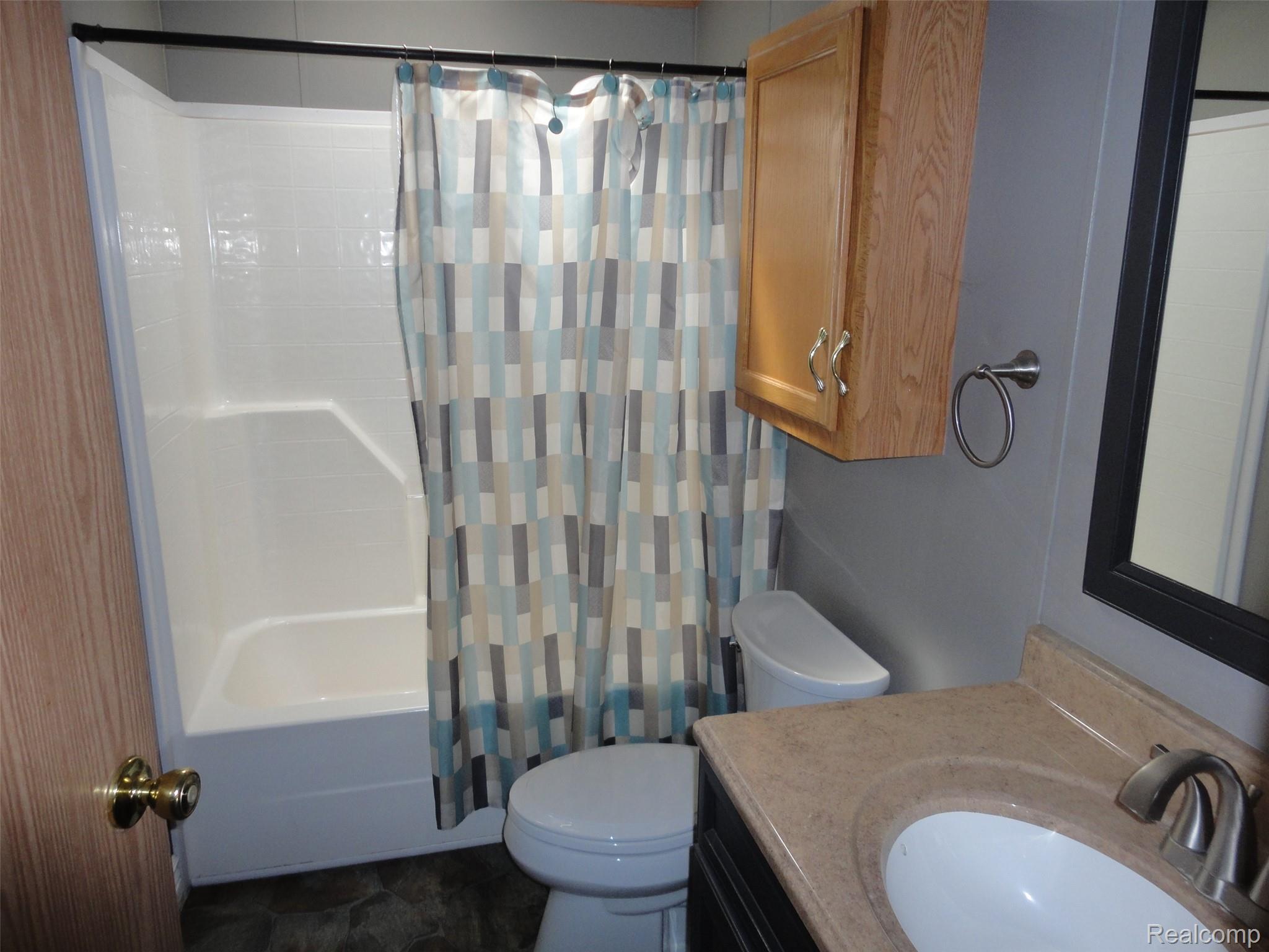 3954 Ryans Ridge Monroe, MI 48161 - Photo 22 of 28 Hall Full bathroom featuring a white tub/shower combination, a toilet, and a vanity with an integrated sink and a neutral-toned countertop
