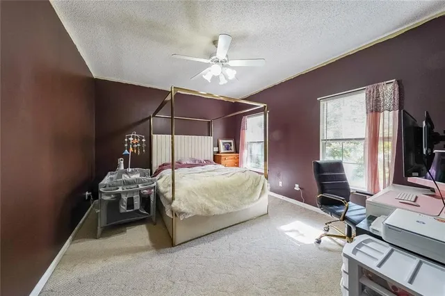 a bedroom with a bed a desk and chair with the bookshelf