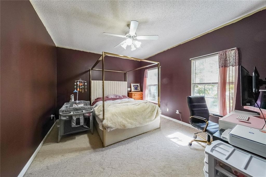 6554 Fox Run Winston, GA 30187 - Photo 13 of 40 a bedroom with a bed a desk and chair with the bookshelf