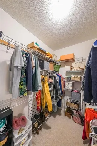 a view of walk in closet with clothes and shoes
