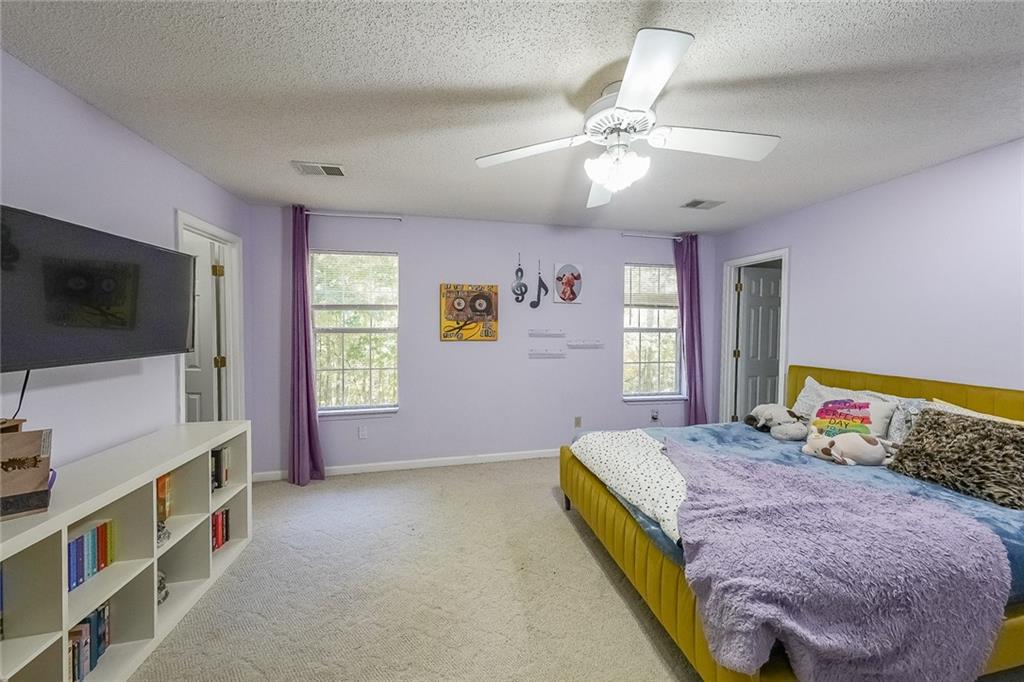 6554 Fox Run Winston, GA 30187 - Photo 22 of 40 a spacious bedroom with a bed and a flat screen tv