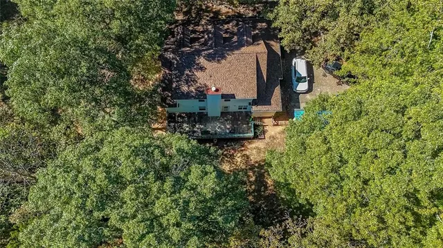an aerial view of a house with large trees