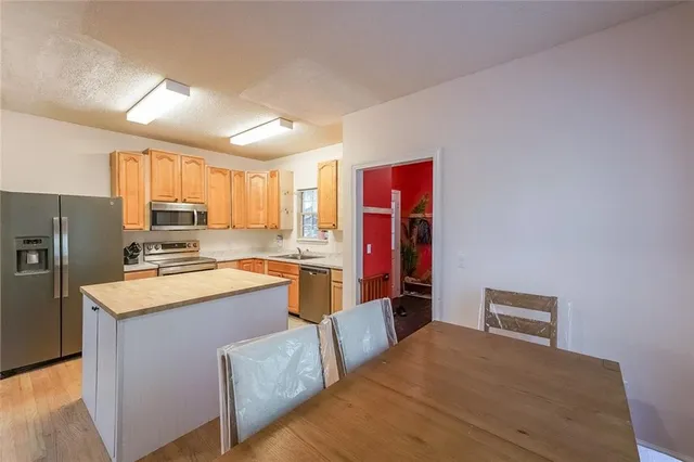 a kitchen with stainless steel appliances granite countertop a stove refrigerator sink window and a refrigerator