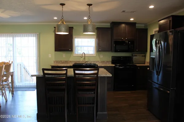 a kitchen with a refrigerator a sink and wooden floor