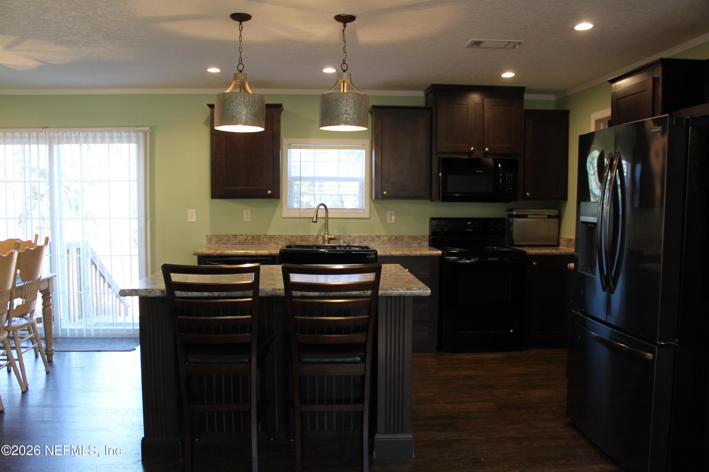 221 Magnolia Road Hawthorne, FL 32640 - Photo 11 of 18 a kitchen with a refrigerator a sink and wooden floor