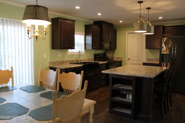 a kitchen with a table chairs refrigerator and microwave