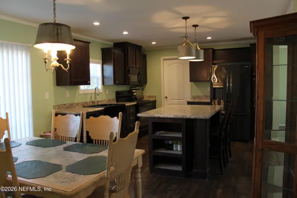 a kitchen with a table chairs refrigerator and microwave