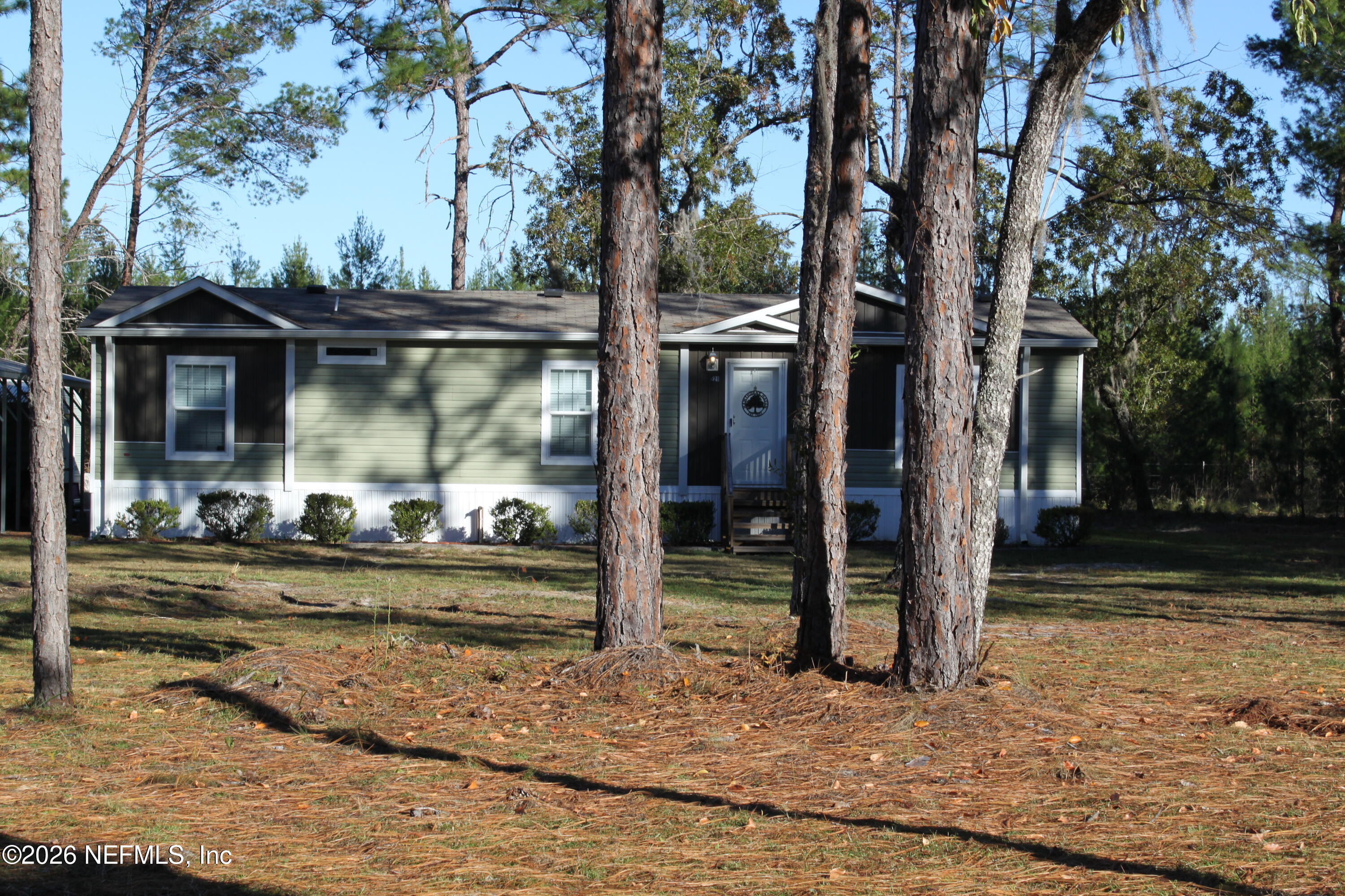 221 Magnolia Road Hawthorne, FL 32640 - Photo 2 of 18 a view of a barn house next to a yard with large tree
