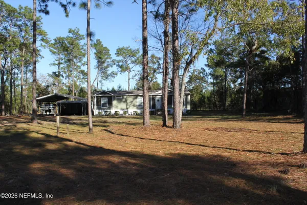 a view of a yard with wooden fence