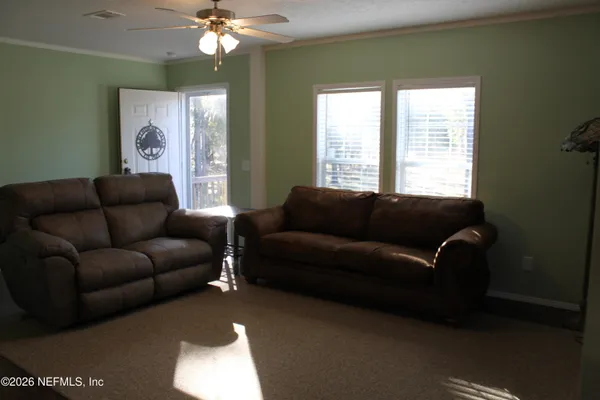 a living room with furniture and a chandelier