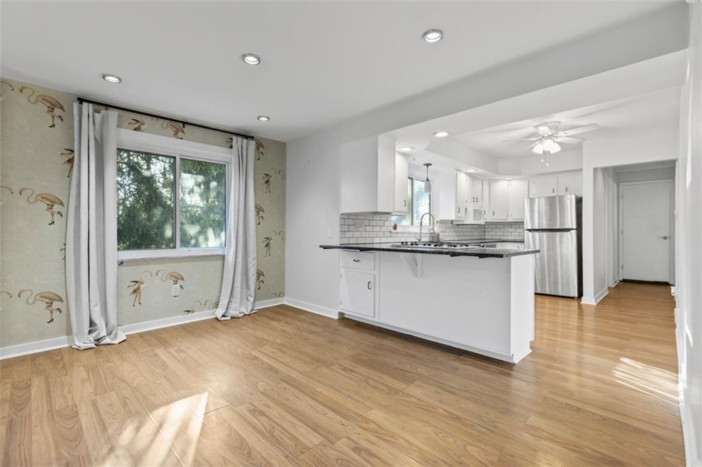 2219 Hill Road South Heights, PA 15081 - Photo 5 of 34 a kitchen with stainless steel appliances granite countertop a stove a sink and a refrigerator with wooden floor