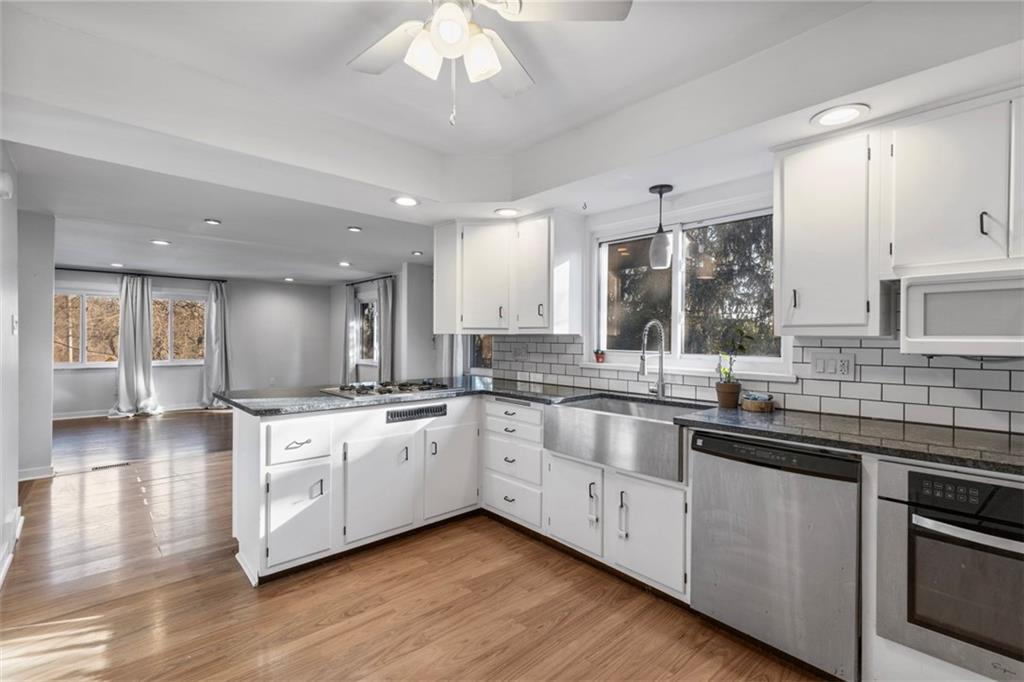 2219 Hill Road South Heights, PA 15081 - Photo 6 of 34 a large white kitchen with stainless steel appliances granite countertop a stove and cabinets