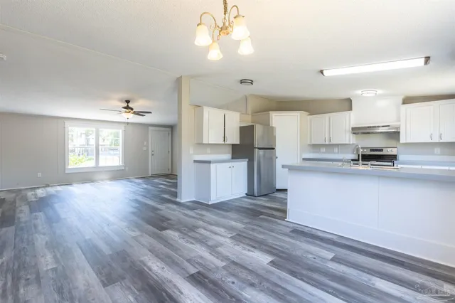 a open kitchen with cabinets wooden floor and stainless steel appliances