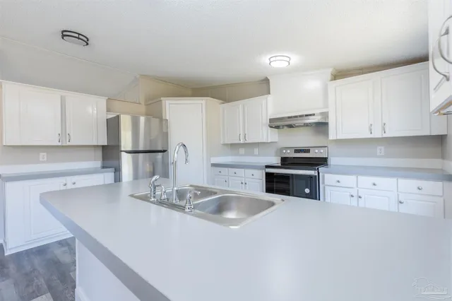 a kitchen with kitchen island a sink stove and refrigerator