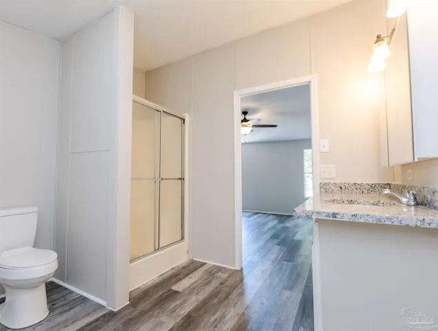 a bathroom with a granite countertop sink toilet and mirror