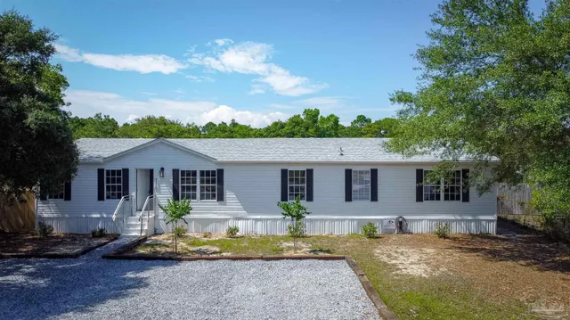 a view of a house with backyard and sitting area