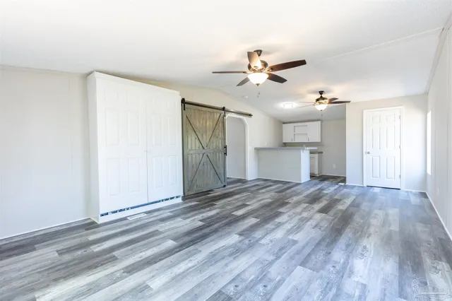 a view of a livingroom with a ceiling fan window and a kitchen