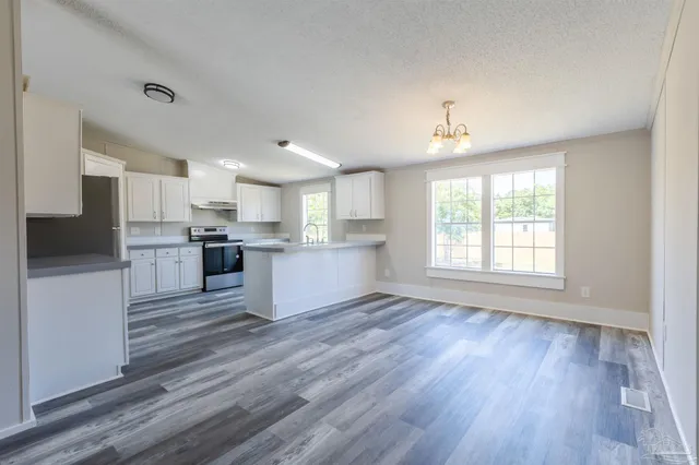 a view of kitchen with wooden floor and electronic appliances