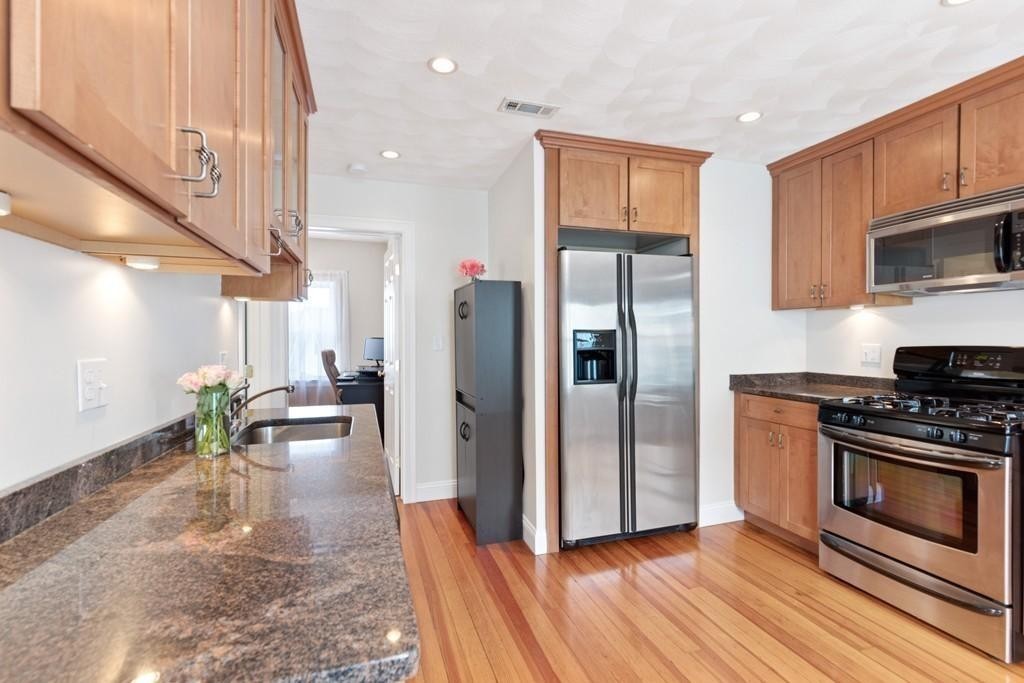 a kitchen with stainless steel appliances a stove a refrigerator and a fireplace