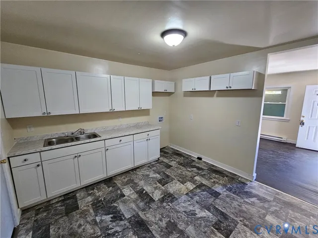 a room with a sink a refrigerator and cabinets
