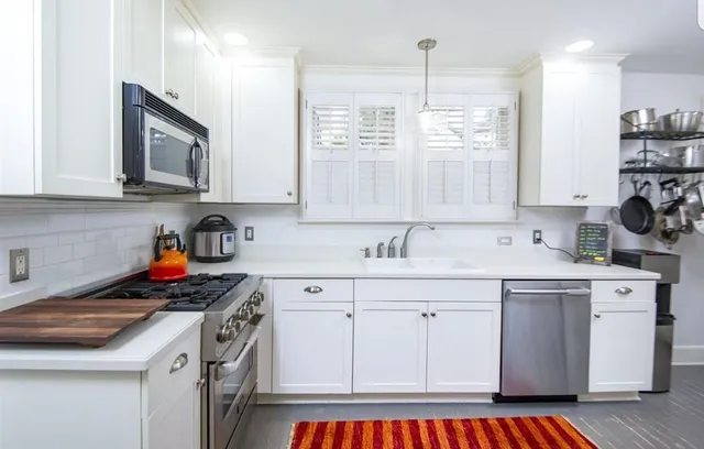 a kitchen with stainless steel appliances granite countertop a sink stove and cabinets